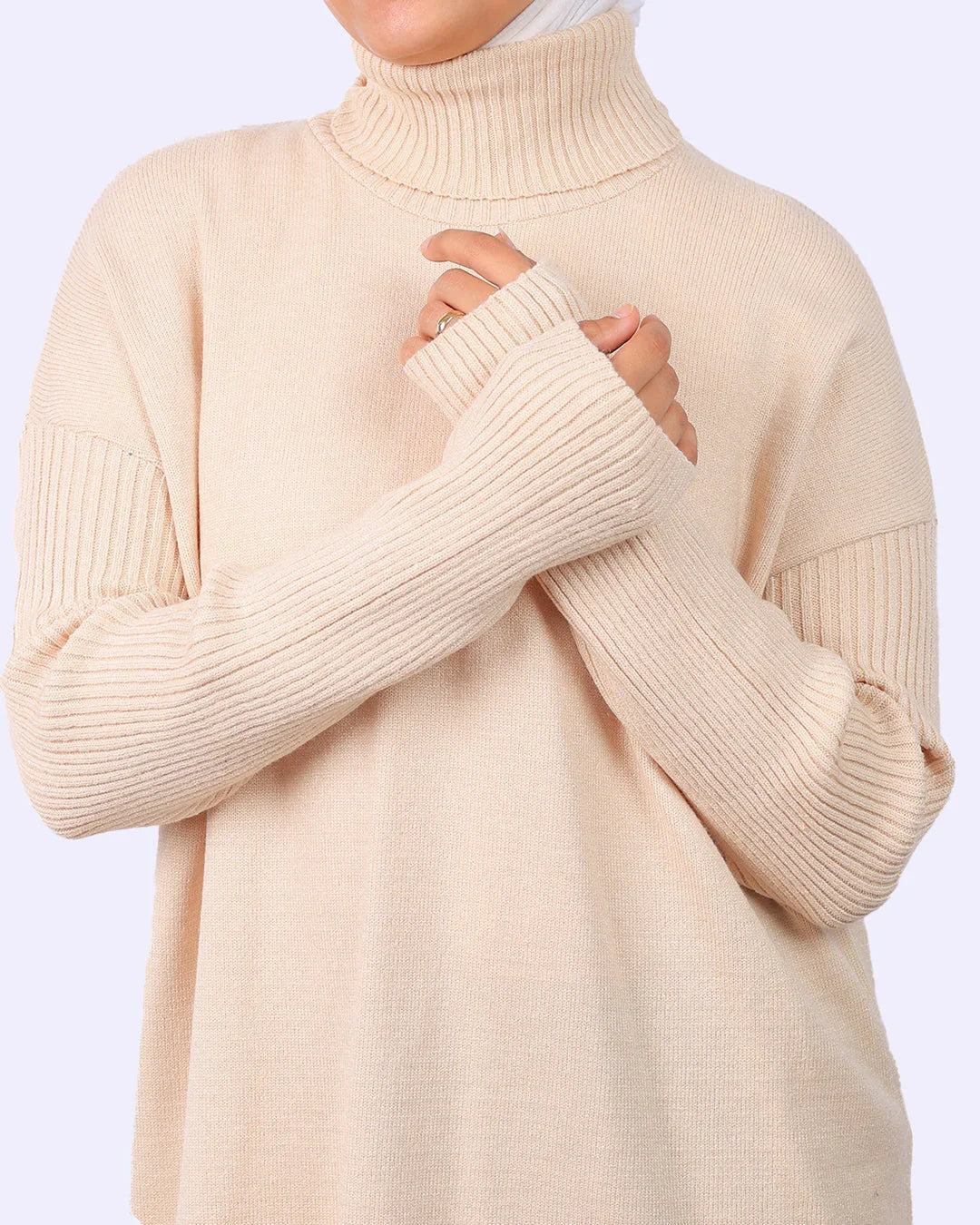 Woman wearing a beige ribbed knit turtleneck sweater from WIND Shopping