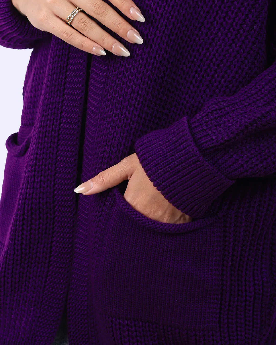 Close-up of woman wearing purple knit cardigan with front pocket from WIND Shopping