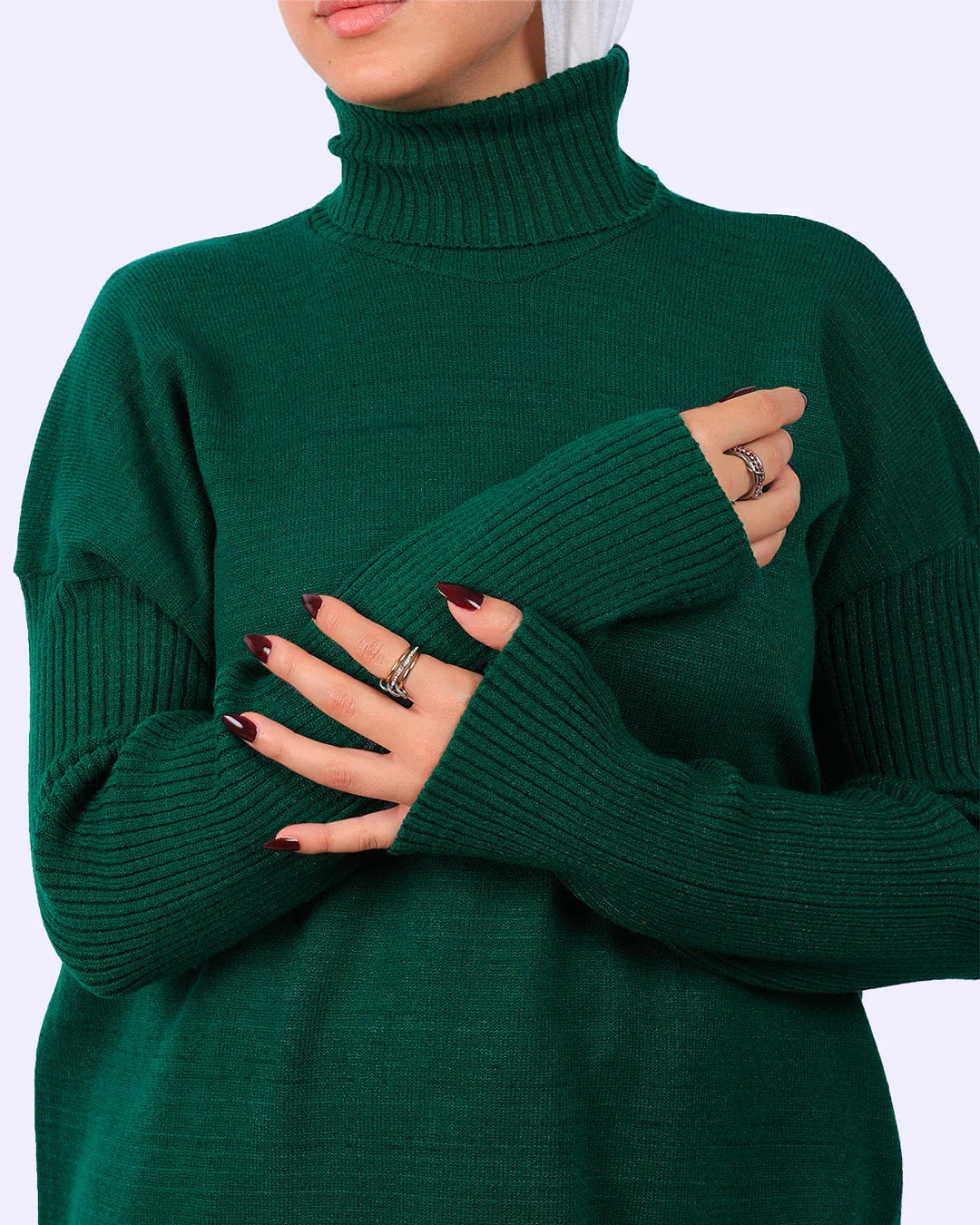 Woman wearing a green knit turtleneck sweater from WIND Shopping, showcasing ribbed sleeves