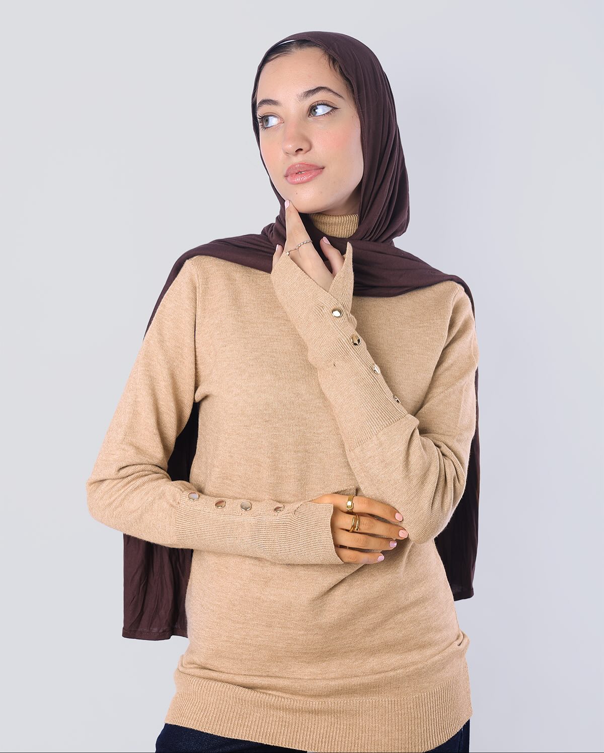 "توب هاي نيك (High Neck) من Wind بلون بيج رملي بلمعة ميتاليك ذهبية ناعمة، تصميم "مينيماليست" بخامة مرنة تمنحك إطلالة راقية وهادئة - ويند"