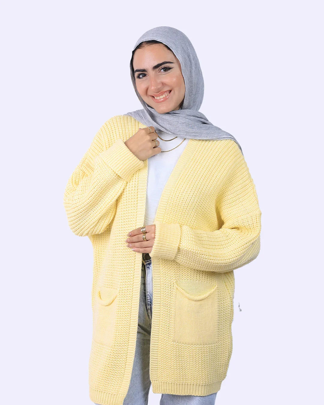 Smiling woman in gray hijab and yellow cardigan from WIND Shopping fashion collection