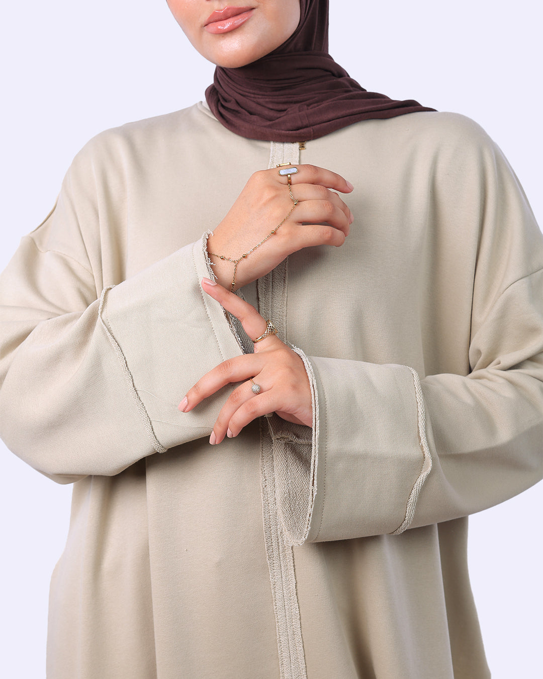 Beige abaya worn by a person with a plain background