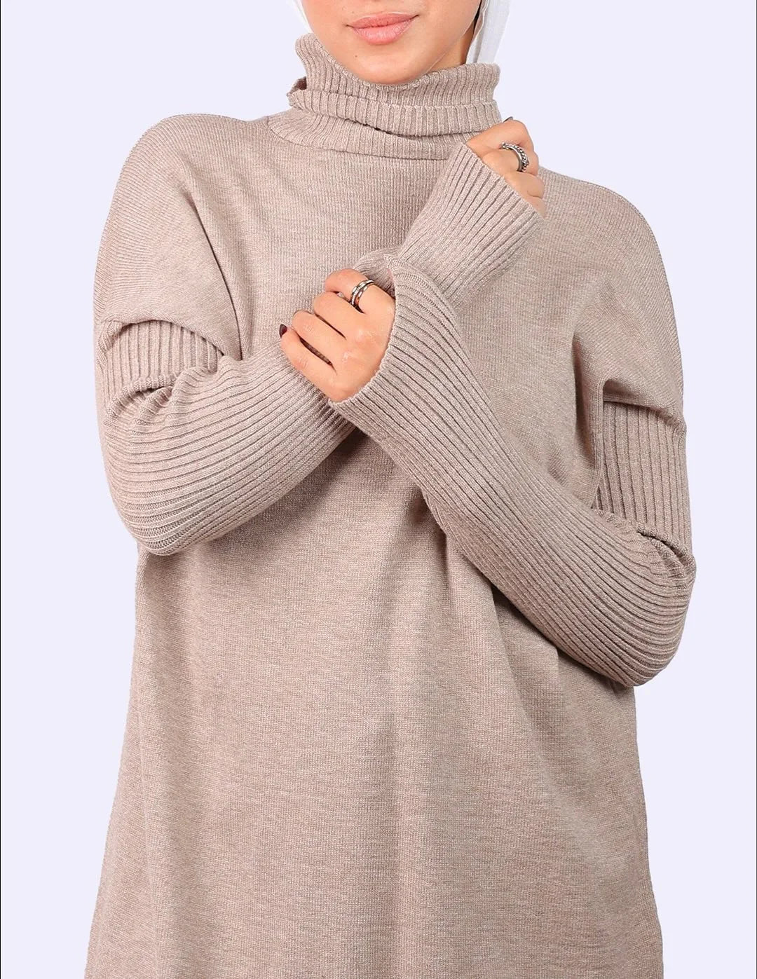 Woman in beige turtleneck sweater from WIND Shopping, showcasing ribbed sleeves.