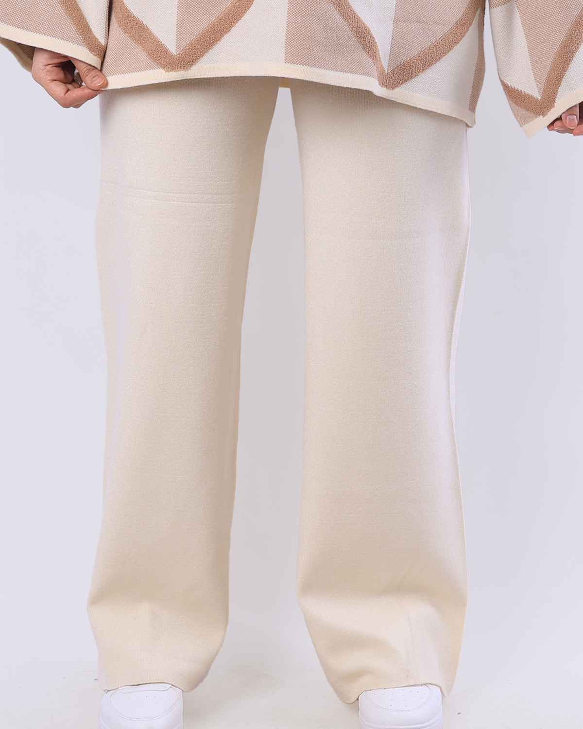 Beige pants worn by a person on a plain background