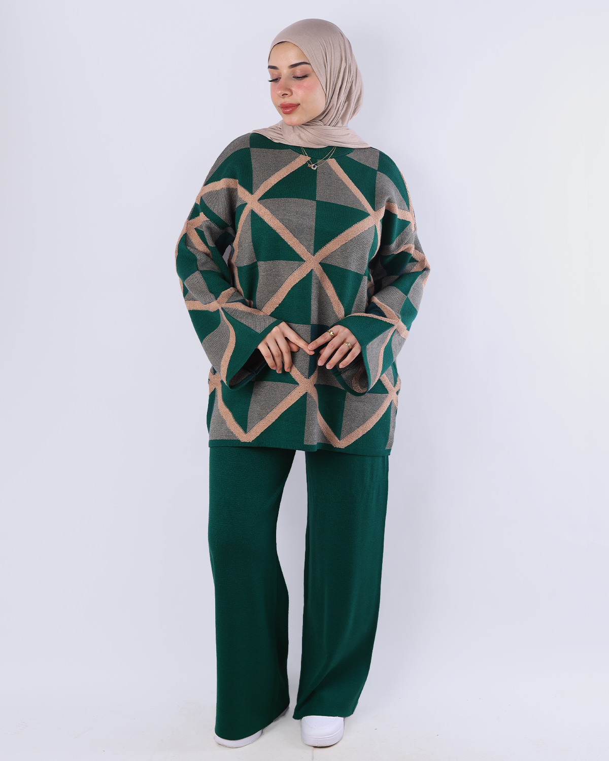 Woman wearing a green and beige geometric patterned outfit on a white background