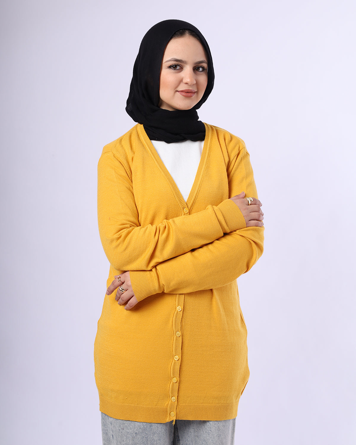 Woman wearing a yellow cardigan over a white shirt with a black hijab on a white background- WIND Shopping