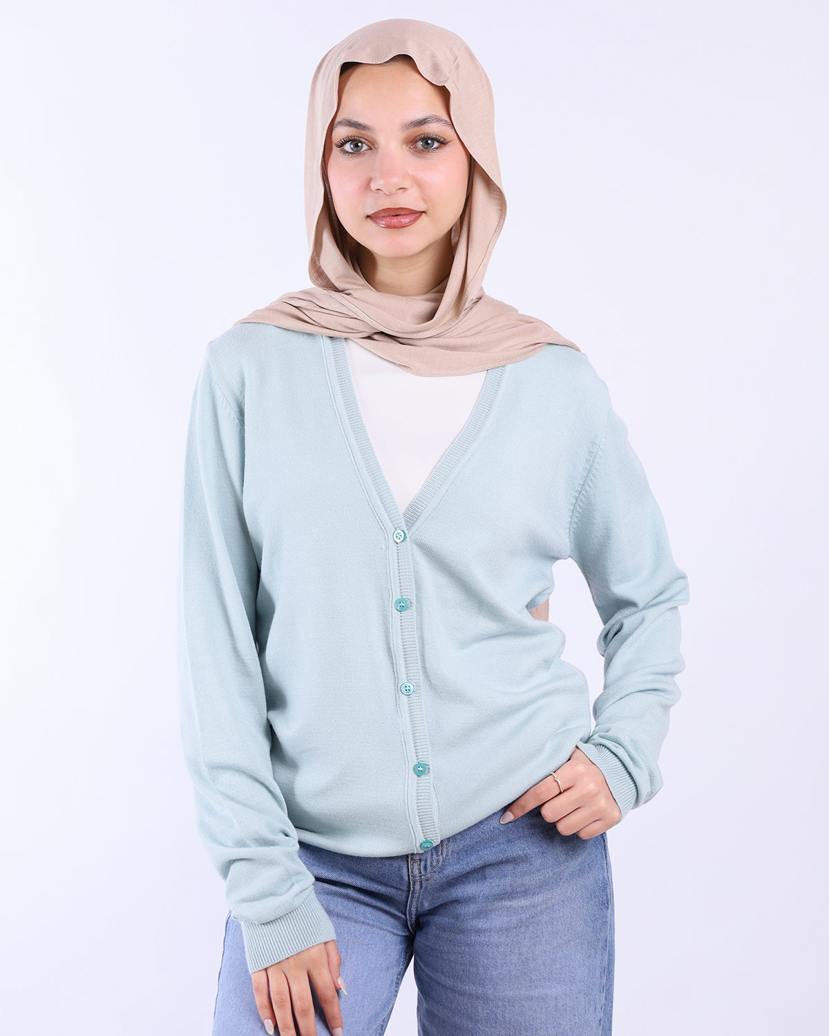 Woman wearing a light blue cardigan and beige hijab on a white background- WIND Shopping