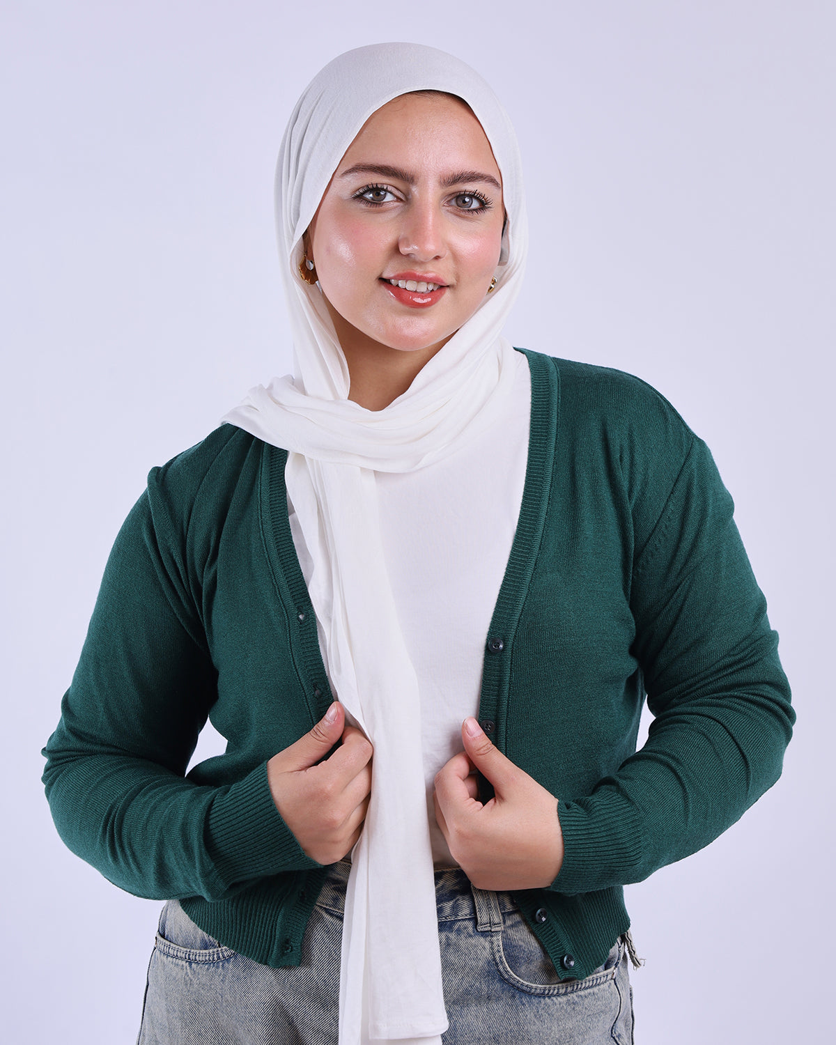 Woman wearing a green cardigan and white hijab on a plain background-WIND Shopping