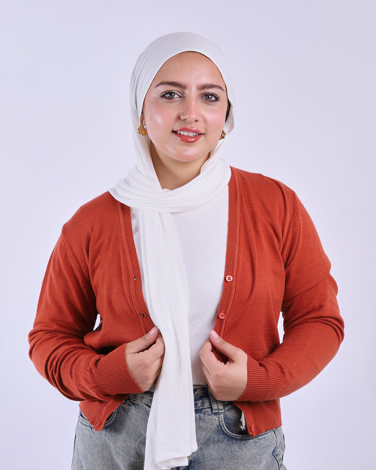 Woman wearing a orange cardigan over a white shirt with a hijab on a white background-WIND Shopping