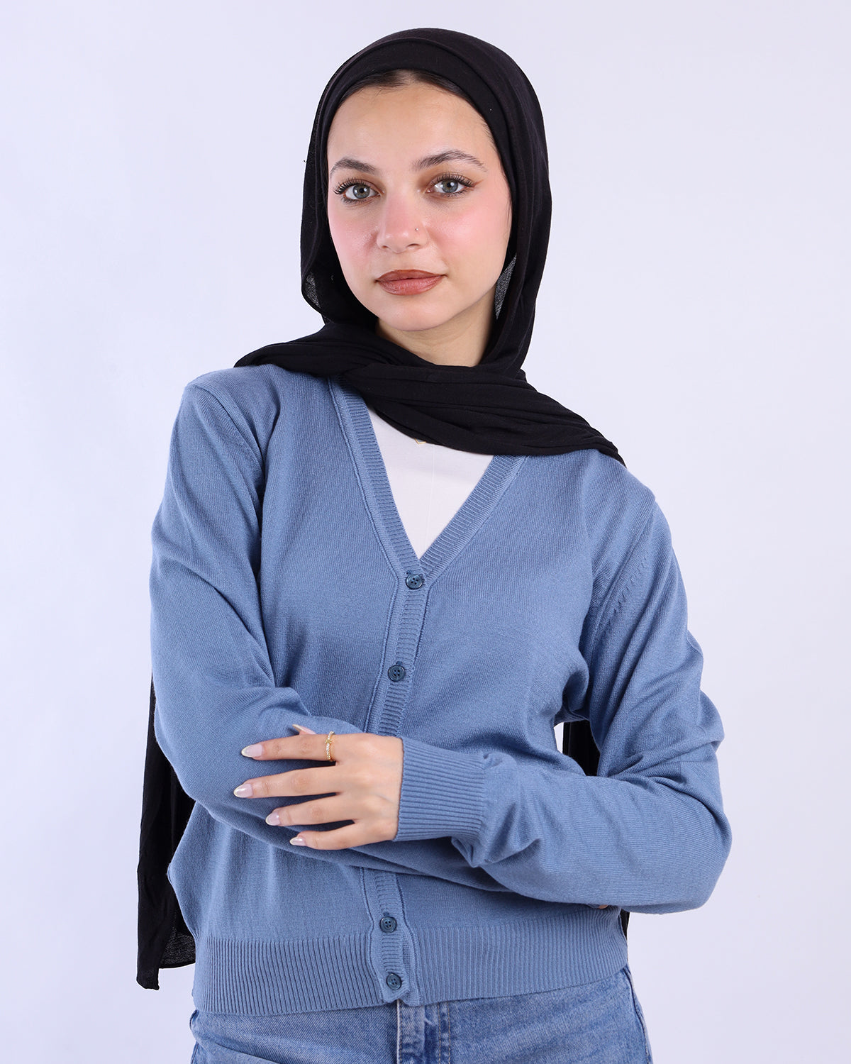 Woman wearing a blue cardigan over a white shirt with a black hijab on a white background-WIND Shopping