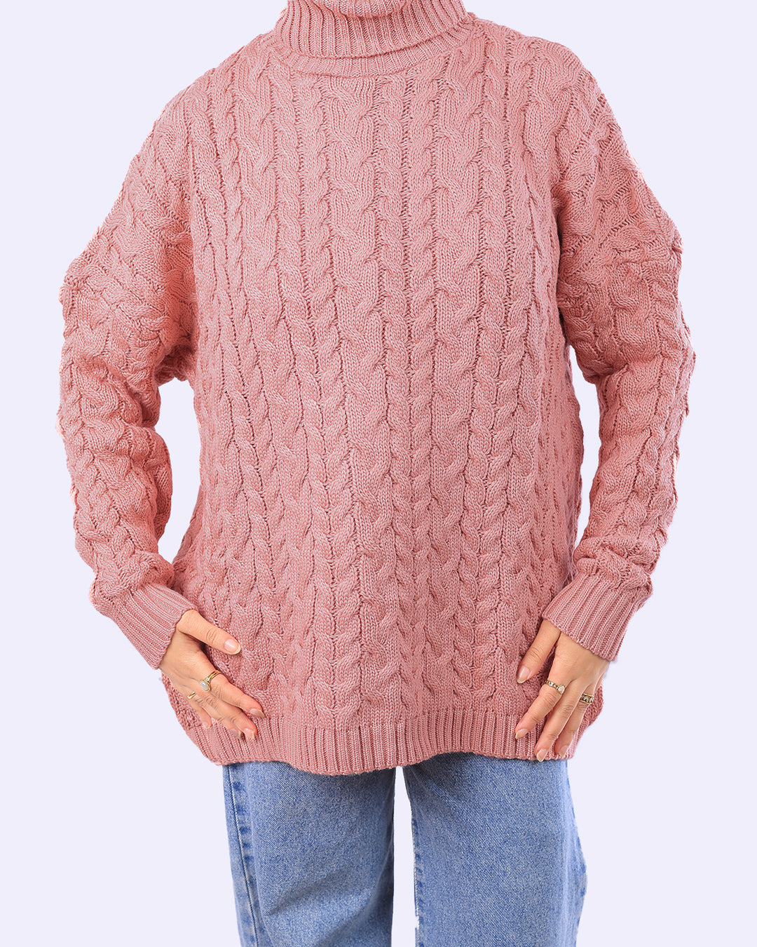 Woman wearing a pink cable knit turtleneck sweater and blue jeans from WIND Shopping