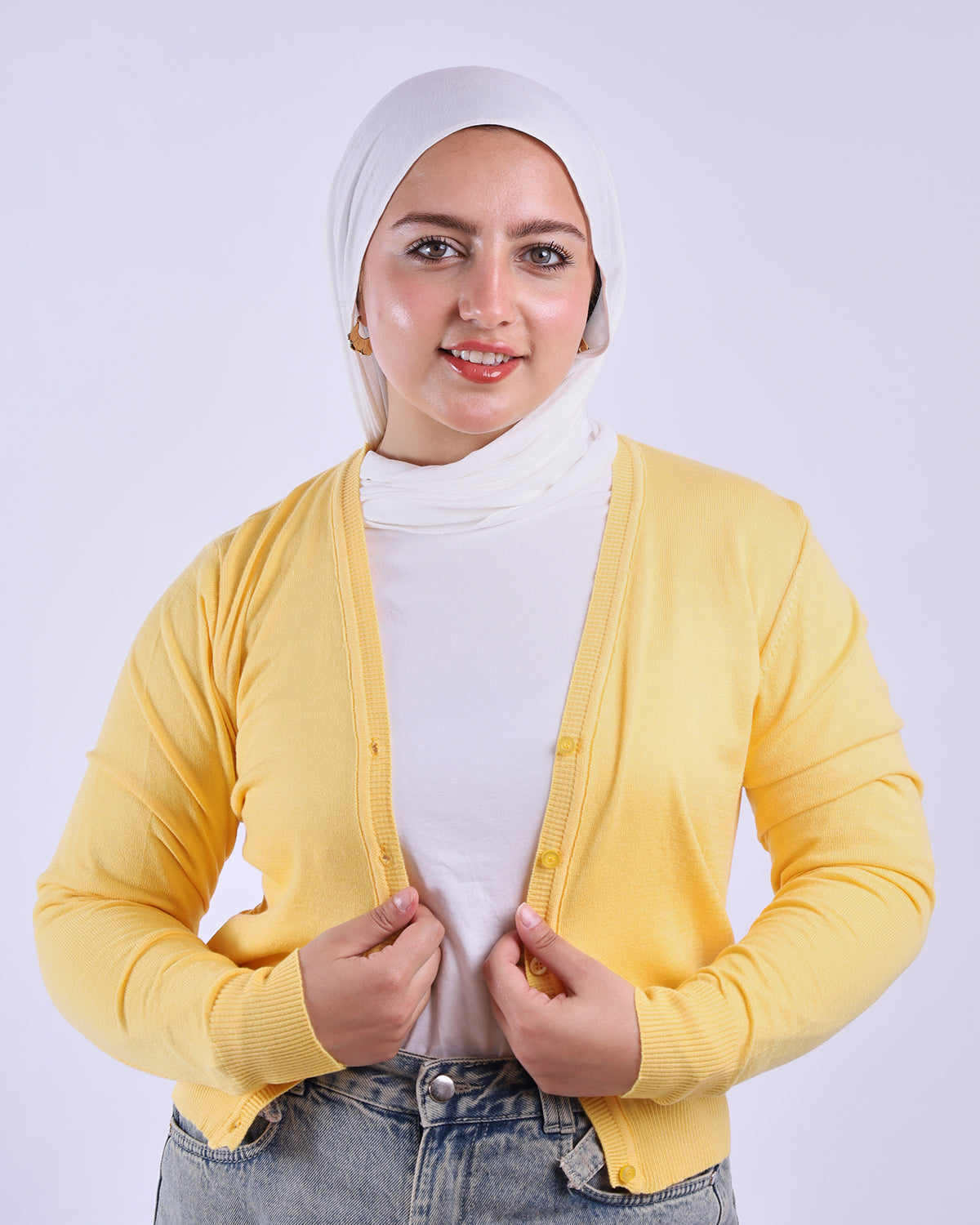 Woman wearing a yellow cardigan over a white turtleneck on a white background- WIND Shopping