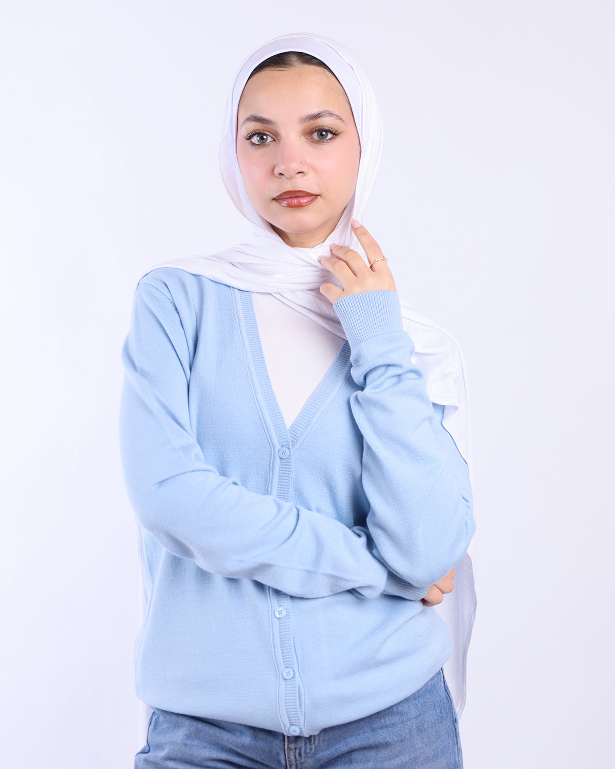 Woman wearing a light blue cardigan and white hijab on a white background- WIND Shopping