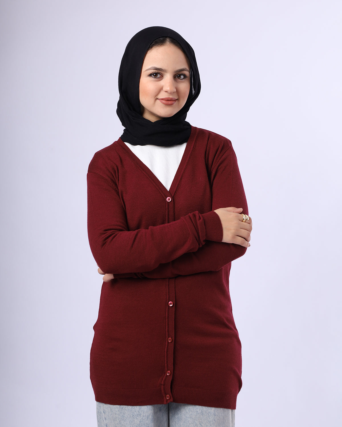 Woman wearing a maroon cardigan over a white shirt with a black hijab on a white background- WIND Shopping