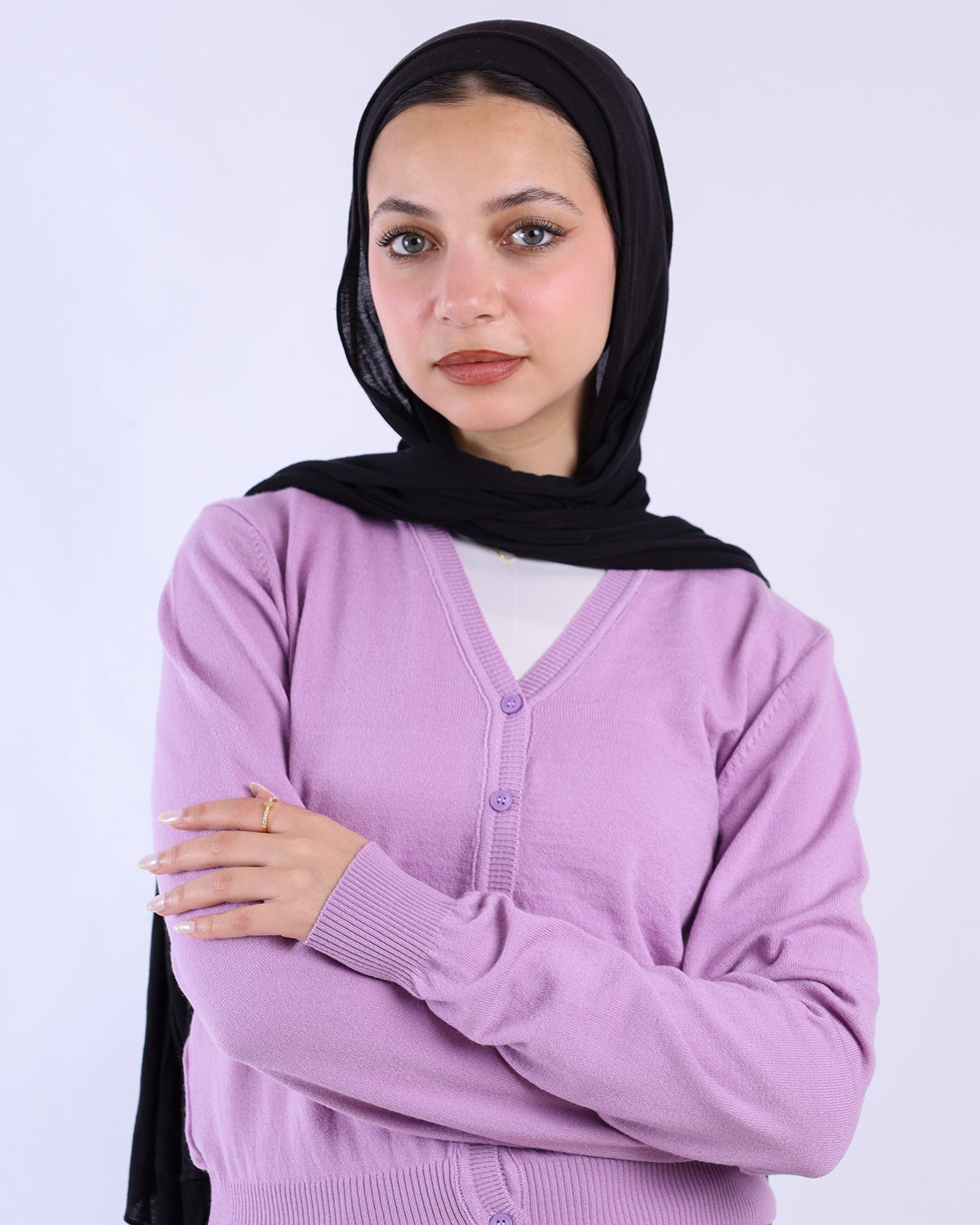 Woman wearing a black hijab and purple sweater against a white background- WIND Shopping