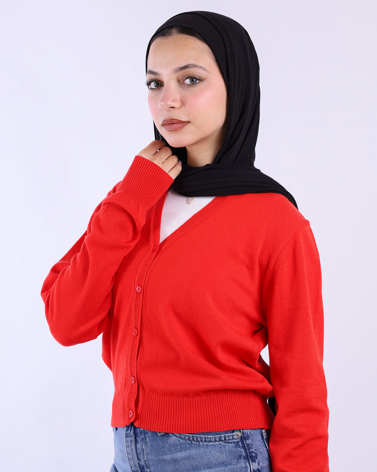 Woman wearing a red cardigan over a white shirt with a black hijab on a white background-WIND Shopping