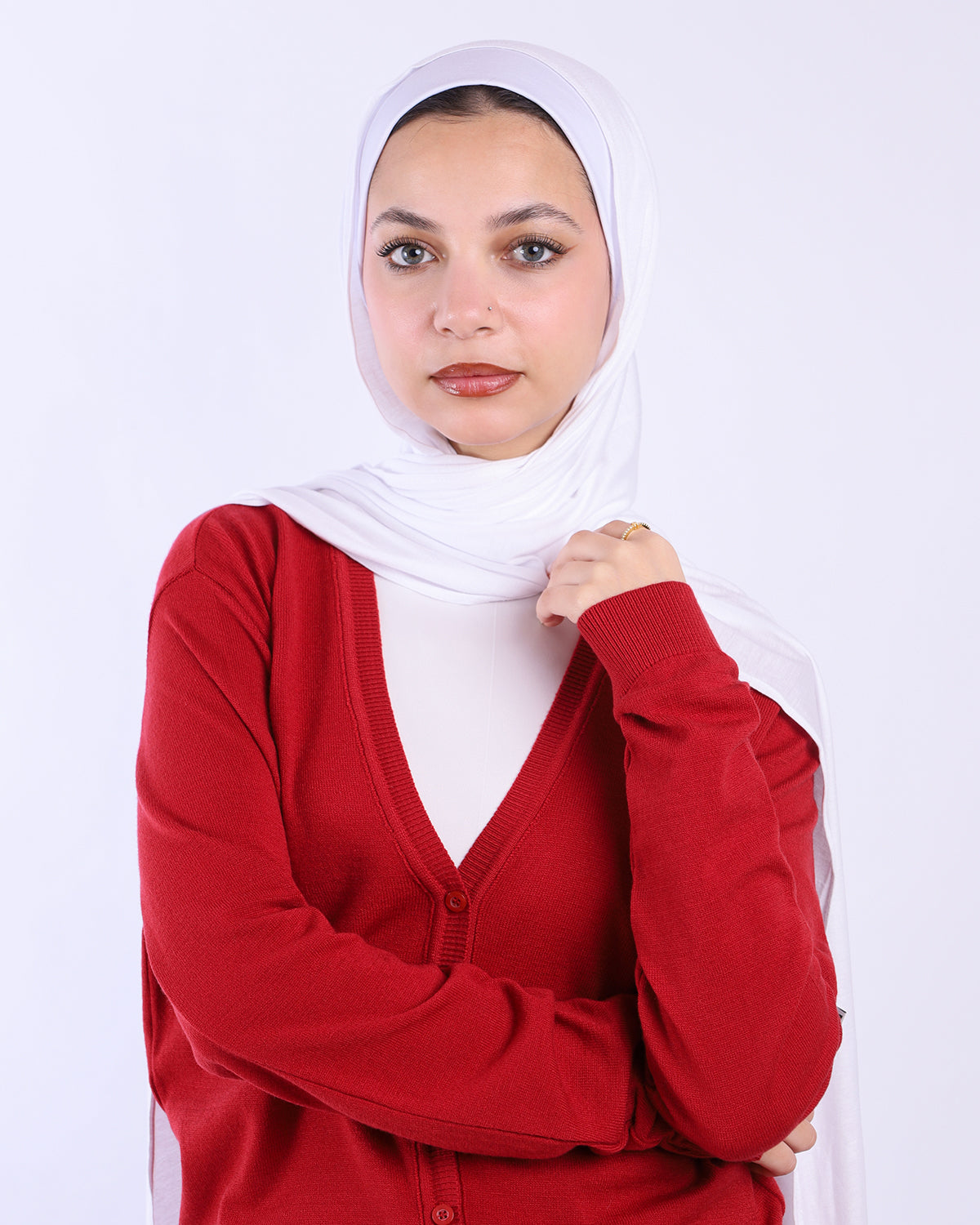 Woman wearing a red cardigan and white hijab on a white background- WIND Shopping