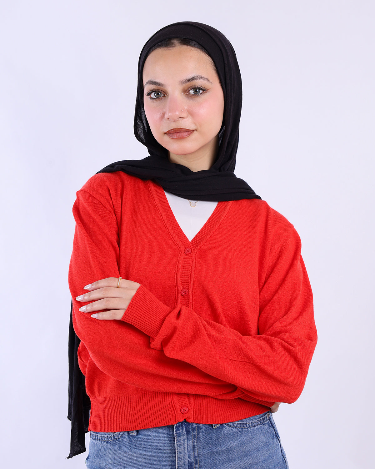 Woman wearing a red cardigan over a white shirt with a black hijab on a white background-WIND Shopping