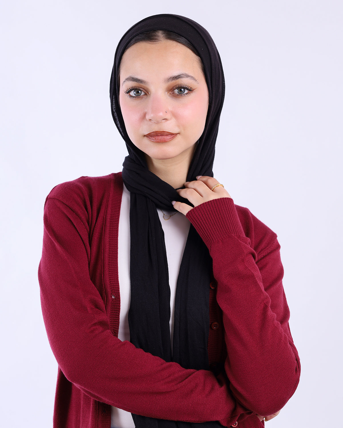 Woman wearing a red cardigan and black hijab against a white background- WIND Shopping