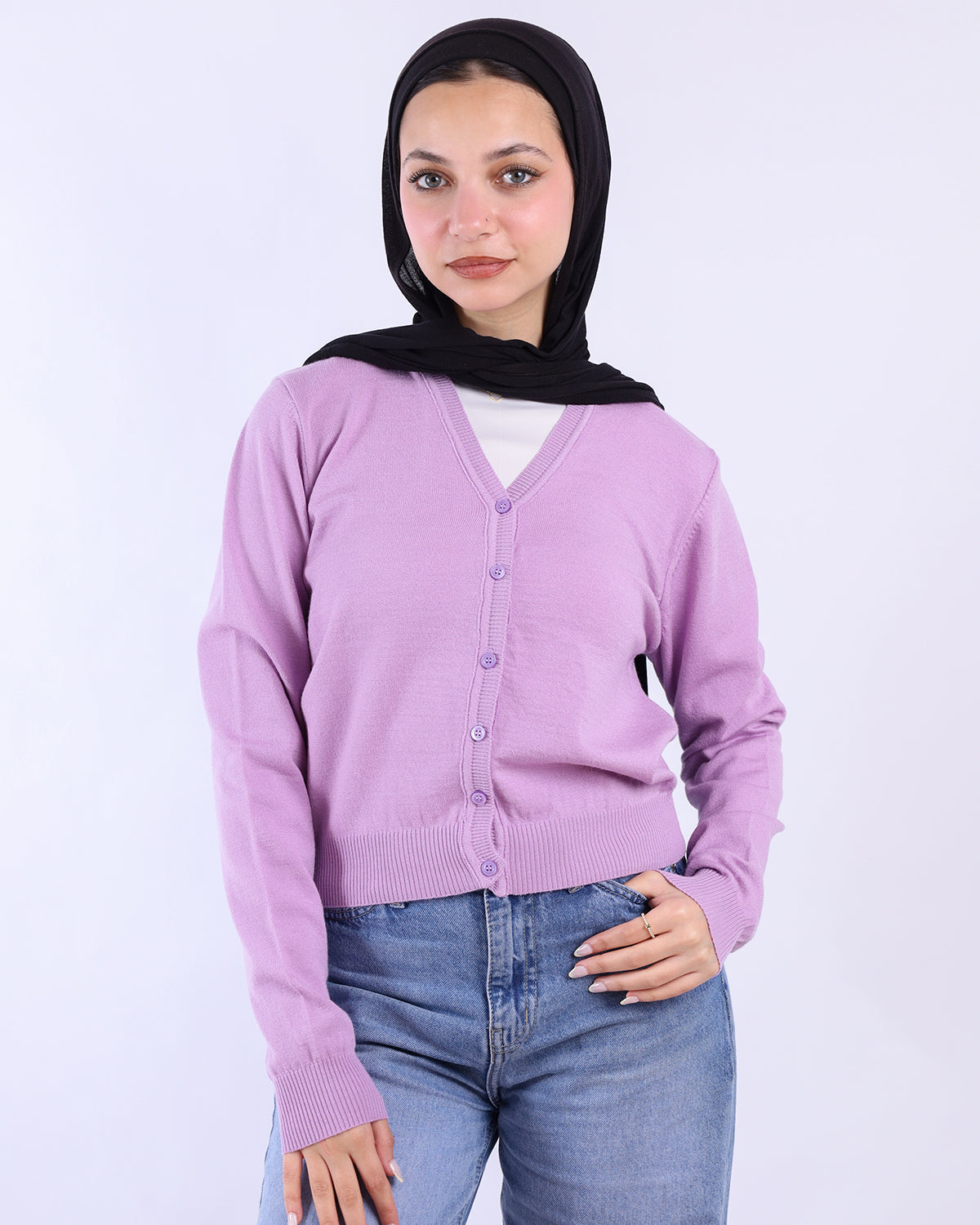 Woman wearing a light purple cardigan over a white shirt with a black hijab on a white background- WIND Shopping